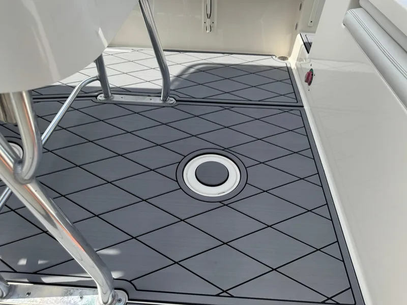 Slide: The Image of 2020 Cobia 220 Center Console boat deck with diamond-patterned flooring and metal supports. - 35