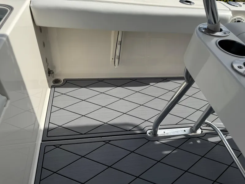 Slide: The Image of 2020 Cobia 220 Center Console boat deck with gray diamond-patterned flooring. - 39