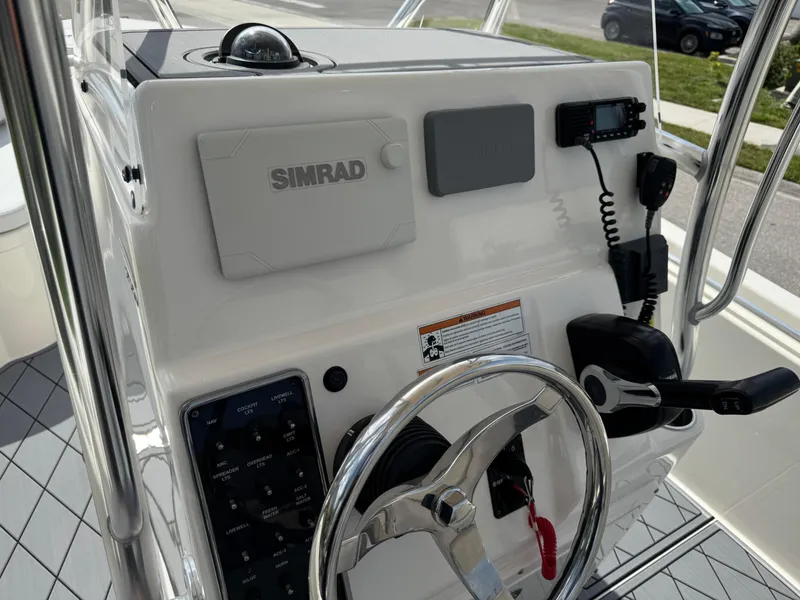 Slide: The Image of 2020 Cobia 220 Center Console boat dashboard with Simrad electronics and steering wheel. - 43