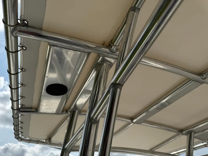 Slide: The Image of 2020 Cobia 220 Center Console boat's T-top frame and canopy under a blue sky. - 44