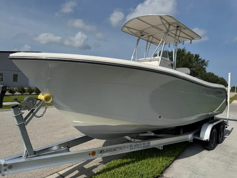 Slide: The Image of 2020 Cobia 220 Center Console boat on trailer, parked outdoors under a clear sky. - 8