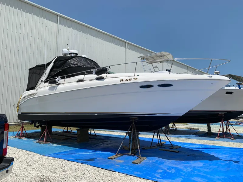 Slide: The Image of 2002 Sea Ray 340 Sundancer yacht on stands, outdoor storage, sunny day. - 0