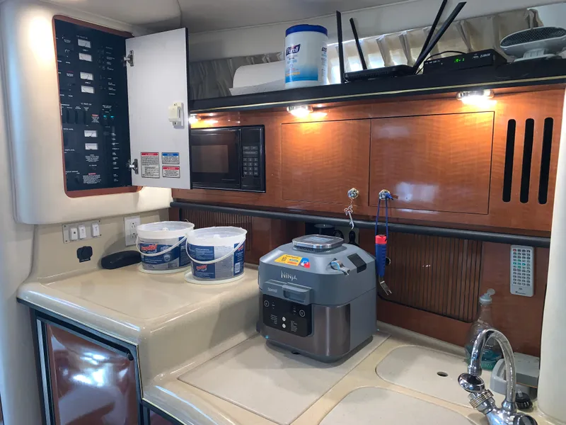 Slide: The Image of 2002 Sea Ray 340 Sundancer kitchen with microwave, control panel, and countertop appliances. - 12
