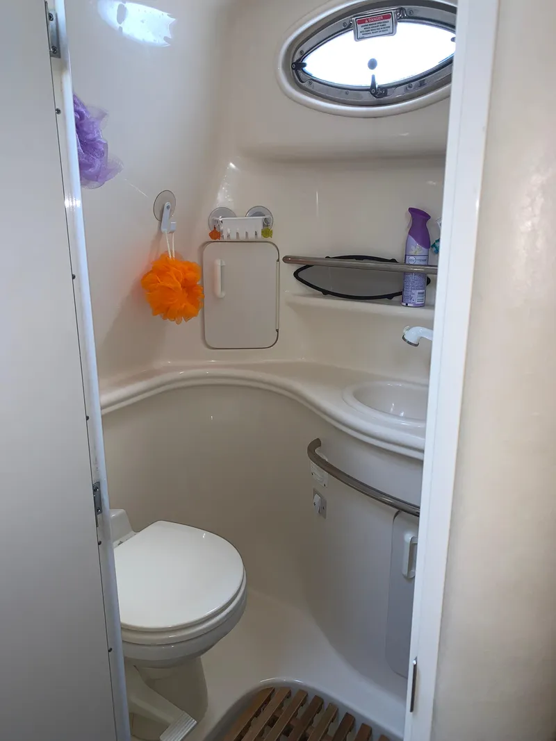 Slide: The Image of Compact bathroom in 2002 Sea Ray 340 Sundancer boat, featuring toilet, sink, and storage. - 14