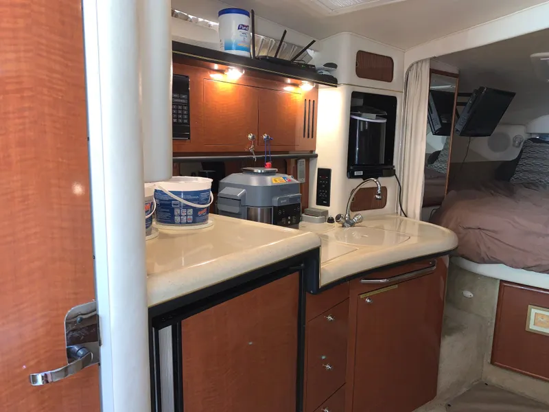 Slide: The Image of 2002 Sea Ray 340 Sundancer interior with kitchenette and cozy sleeping area. - 15