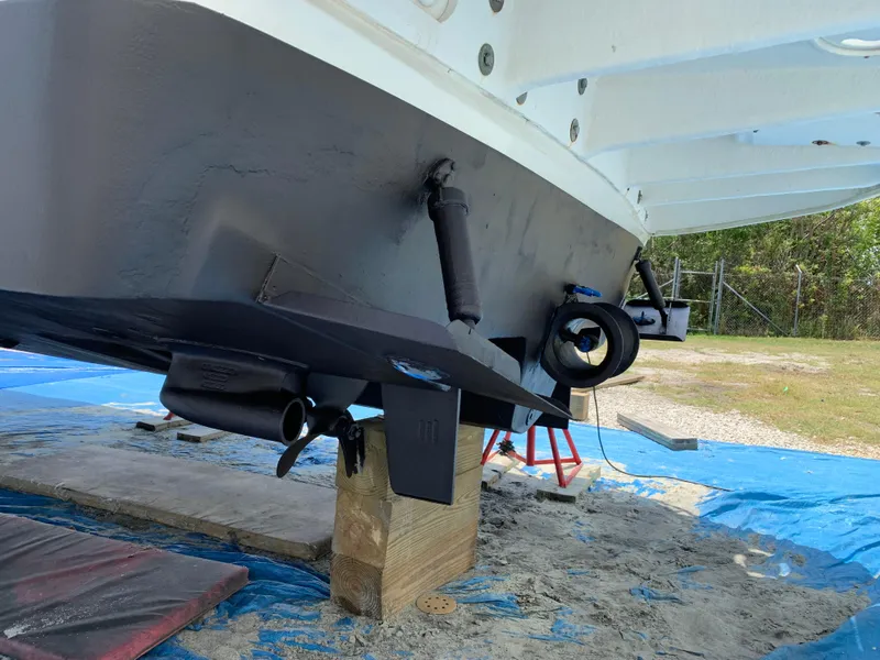 Slide: The Image of 2002 Sea Ray 340 Sundancer boat hull on dry dock, showing propeller and rudder. - 16