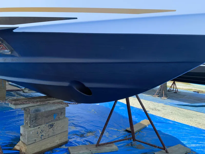 Slide: The Image of 2002 Sea Ray 340 Sundancer boat hull on stands, blue and white paint. - 17