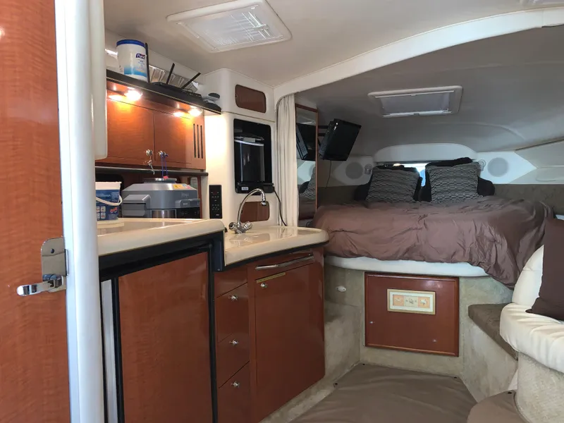 Slide: The Image of 2002 Sea Ray 340 Sundancer cabin interior with kitchenette and cozy sleeping area. - 9