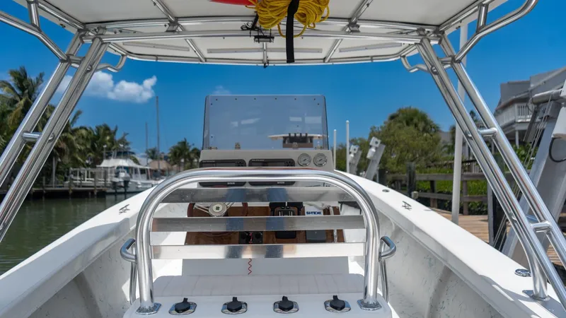 Slide: The Image of 2021 C-Hawk 29CC boat interior with steering console, docked in a marina under clear blue sky. - 14
