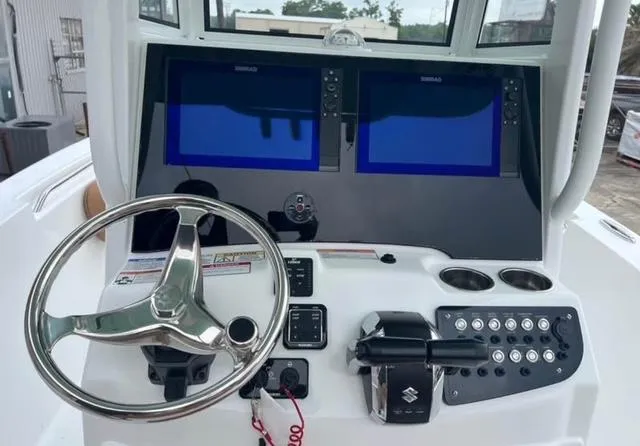 Slide: The Image of 2025 NauticStar 252 Legacy boat dashboard with dual screens and steering wheel. - 10