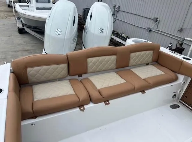 Slide: The Image of 2025 NauticStar 252 Legacy boat with tan and cream cushioned seating. - 12