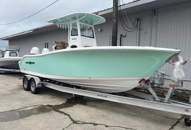 Slide: The Image of 2025 NauticStar 252 Legacy boat on trailer, light blue hull, parked outdoors. - 3