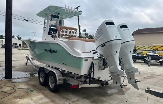 Slide: The Image of 2025 NauticStar 252 Legacy boat on trailer with dual outboard engines. - 5