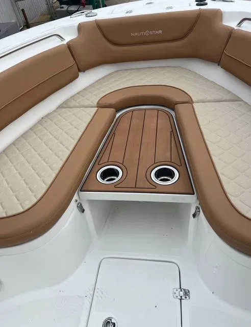 Slide: The Image of 2025 NauticStar 252 Legacy boat interior with tan seating and cup holders. - 7