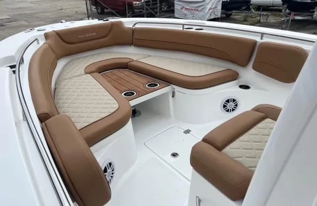 Slide: The Image of Luxurious seating area on 2025 NauticStar 252 Legacy boat with tan upholstery and cup holders. - 8