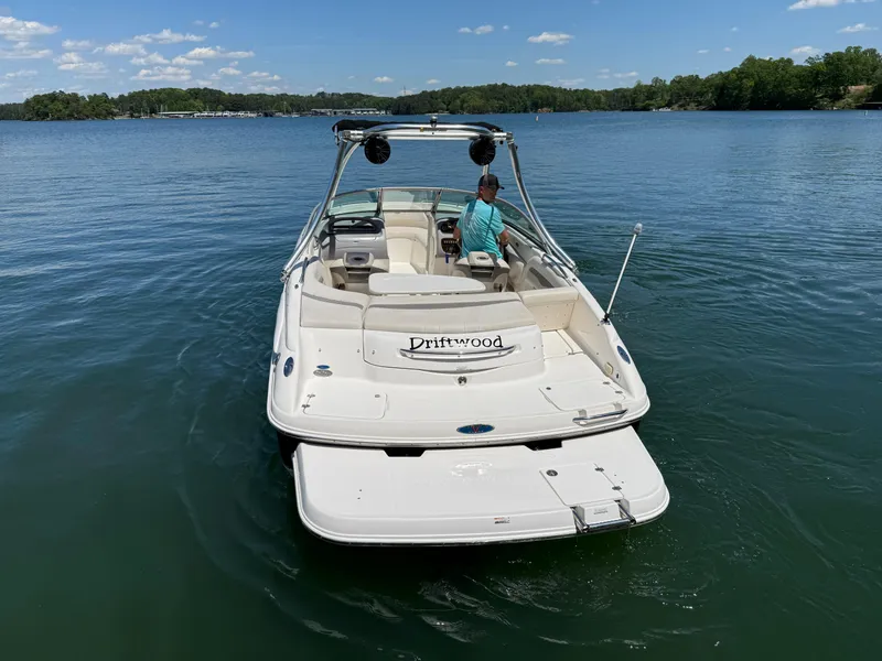 Slide: The Image of 2006 Chaparral 220 SSi boat on a lake with a person onboard, clear sky background. - 10