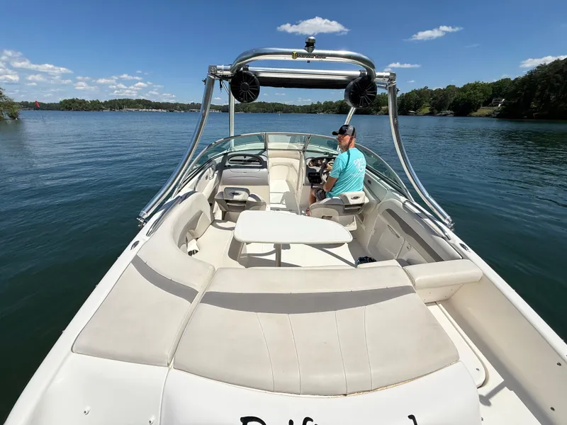 Slide: The Image of 2006 Chaparral 220 SSi boat on a lake, featuring spacious seating and a clear blue sky. - 12