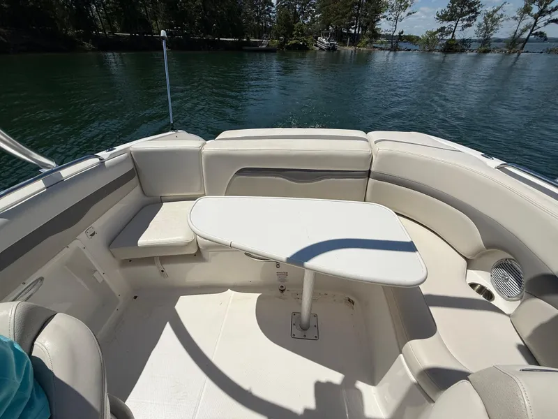 Slide: The Image of 2006 Chaparral 220 SSi boat interior with seating and table on a sunny day. - 15