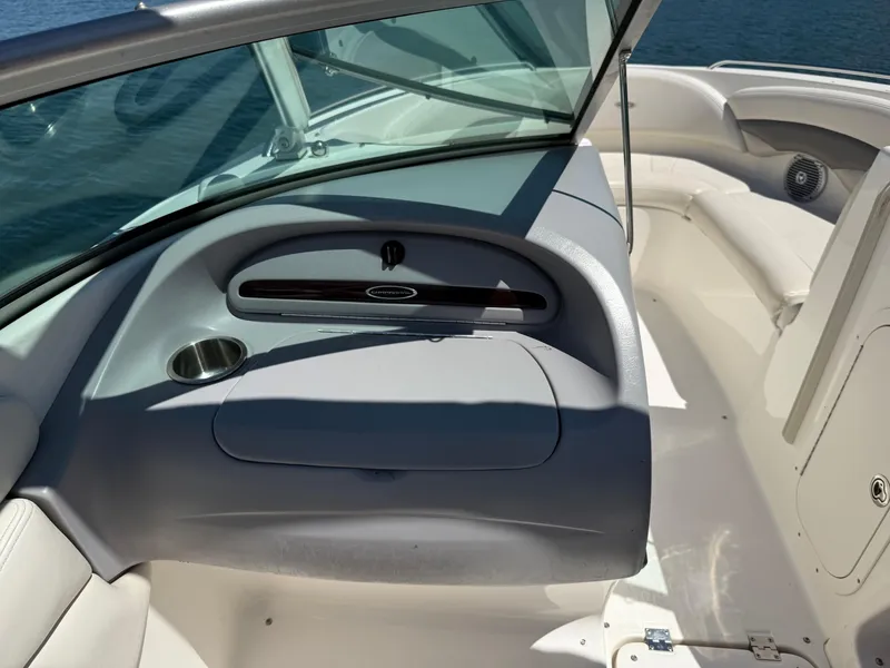 Slide: The Image of 2006 Chaparral 220 SSi boat interior with seating and dashboard, on calm water. - 16