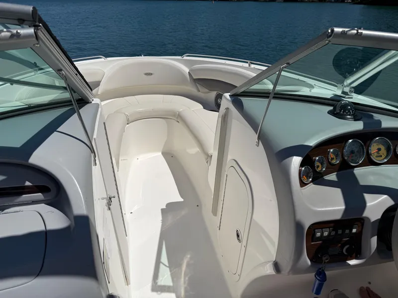 Slide: The Image of 2006 Chaparral 220 SSi boat interior with seating and dashboard, on a calm lake. - 17