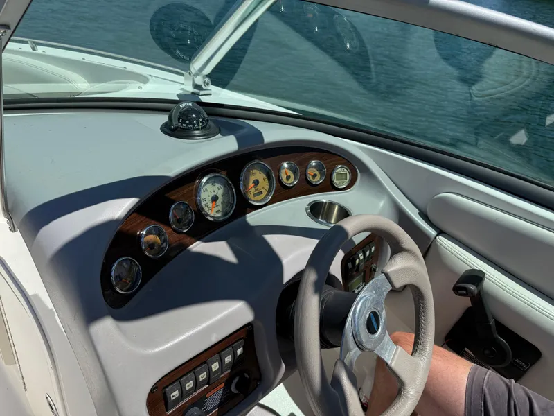 Slide: The Image of 2006 Chaparral 220 SSi boat dashboard with gauges and steering wheel, on water. - 19