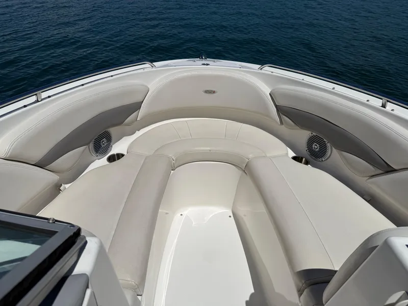 Slide: The Image of 2006 Chaparral 220 SSi boat interior with cushioned seating and cup holders on calm water. - 20