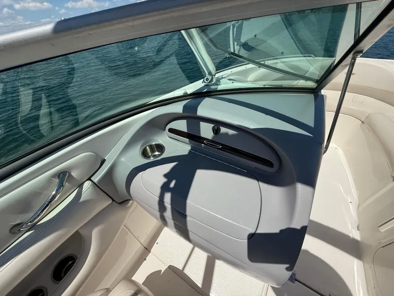 Slide: The Image of 2006 Chaparral 220 SSi boat interior with windshield and seating, on a sunny day. - 23