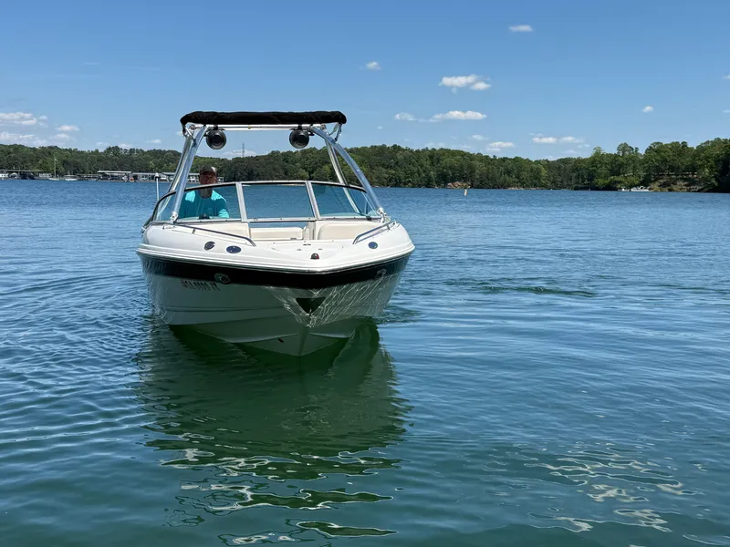 Slide: The Image of 2006 Chaparral 220 SSi boat on a serene lake under a clear blue sky. - 3