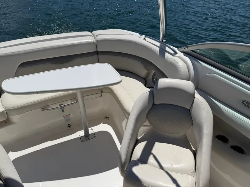 Slide: The Image of 2006 Chaparral 220 SSi boat interior with seating and table on a sunny day. - 30