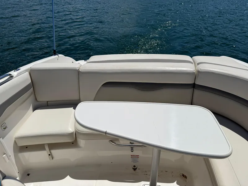 Slide: The Image of 2006 Chaparral 220 SSi boat interior with white seating and table on water. - 31