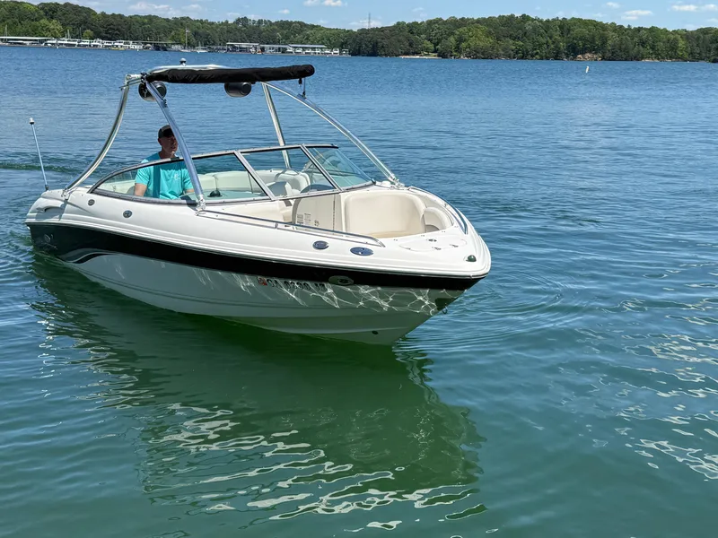 Slide: The Image of 2006 Chaparral 220 SSi boat on a serene lake with lush green shoreline. - 6