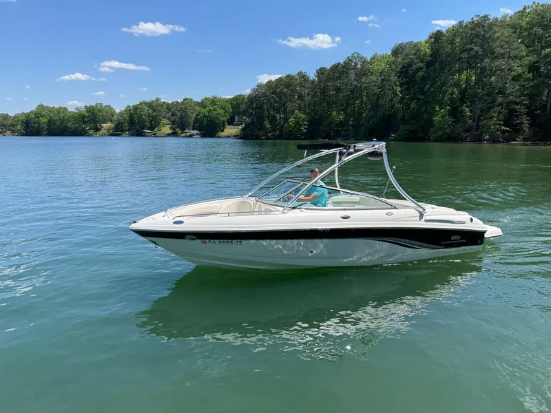 Slide: The Image of 2006 Chaparral 220 SSi boat on a serene lake with lush green trees. - 8