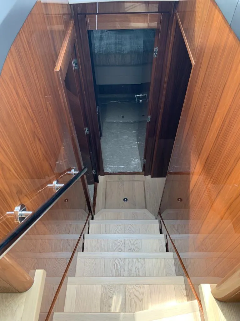 Slide: The Image of Staircase inside 2020 Sunseeker Manhattan 68 yacht with wooden finish and glass railing. - 16
