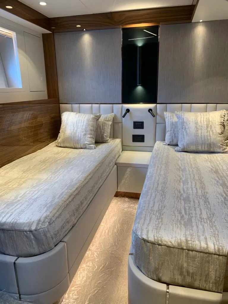 Slide: The Image of Luxurious twin cabin interior of 2020 Sunseeker Manhattan 68 yacht, featuring elegant bedding and lighting. - 20