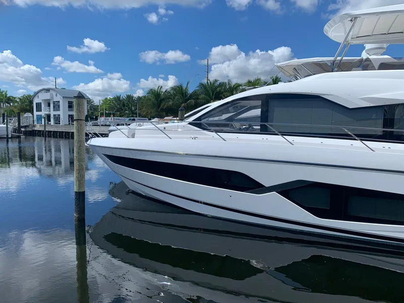 Slide: The Image of 2020 Sunseeker Manhattan 68 yacht docked in a marina under a clear blue sky. - 3