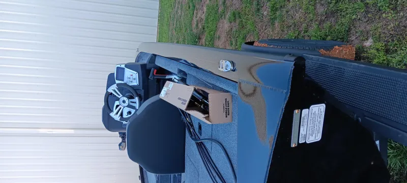 Slide: The Image of 2025 Tracker Pro Team 195 Tournament Edition boat on grass, featuring steering wheel and seat. - 12