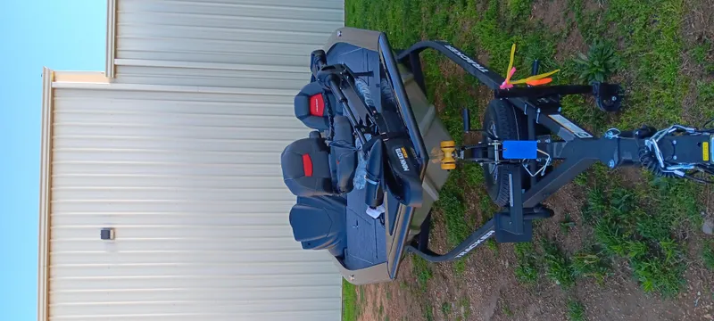 Slide: The Image of 2025 Tracker Pro Team 195 Tournament Edition boat on trailer, parked beside a building. - 3