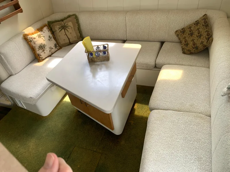 Slide: The Image of Cozy interior of 1994 Mainship 31 Sedan Bridge with cushioned seating and decorative pillows. - 10