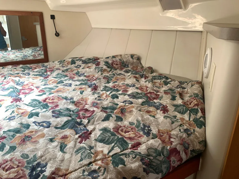 Slide: The Image of Cozy cabin interior of 1994 Mainship 31 Sedan Bridge with floral bedding. - 13