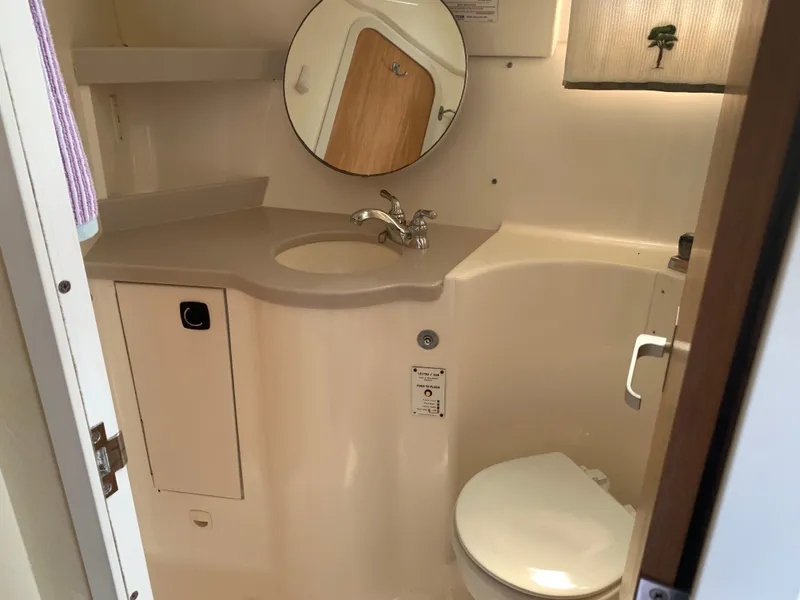 Slide: The Image of 1994 Mainship 31 Sedan Bridge bathroom with sink, mirror, and toilet. - 18