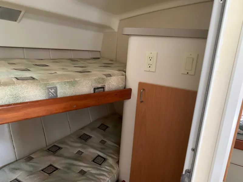Slide: The Image of Interior of 1994 Mainship 31 Sedan Bridge with bunk beds and wooden cabinet. - 23
