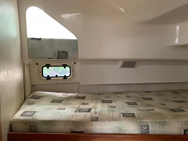 Slide: The Image of 1994 Mainship 31 Sedan Bridge cabin interior with patterned mattress and small window. - 24