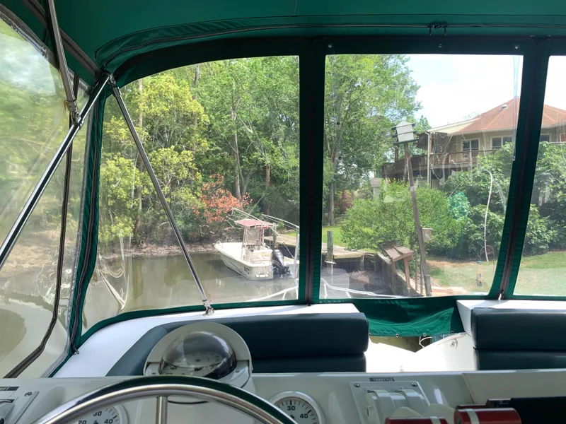 Slide: The Image of Interior view from 1994 Mainship 31 Sedan Bridge, overlooking a serene riverside scene. - 32