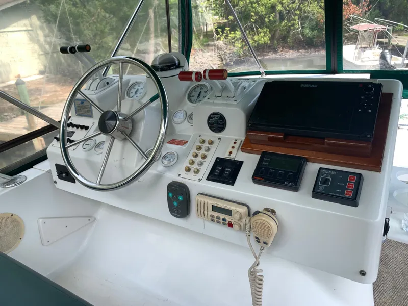 Slide: The Image of 1994 Mainship 31 Sedan Bridge helm with steering wheel, gauges, and navigation equipment. - 33