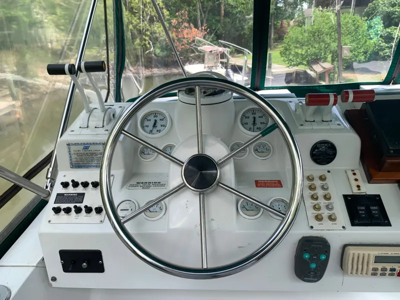 Slide: The Image of 1994 Mainship 31 Sedan Bridge helm with steering wheel and control panel. - 38