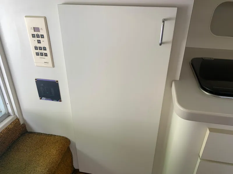 Slide: The Image of Interior of 1994 Mainship 31 Sedan Bridge, featuring control panel and cabinetry. - 4