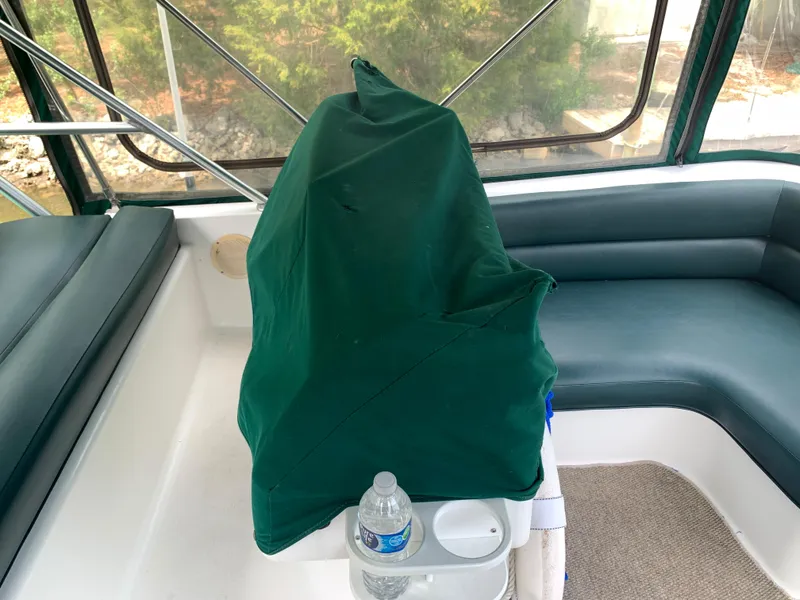 Slide: The Image of 1994 Mainship 31 Sedan Bridge interior with green cover and seating area. - 44