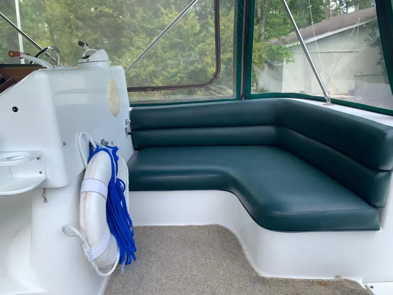 Slide: The Image of 1994 Mainship 31 Sedan Bridge interior with green seating and life preserver. - 45