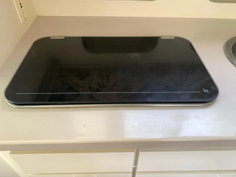 Slide: The Image of Glass stovetop cover on a Mainship 31 Sedan Bridge, 1994 model, in a kitchen setting. - 5