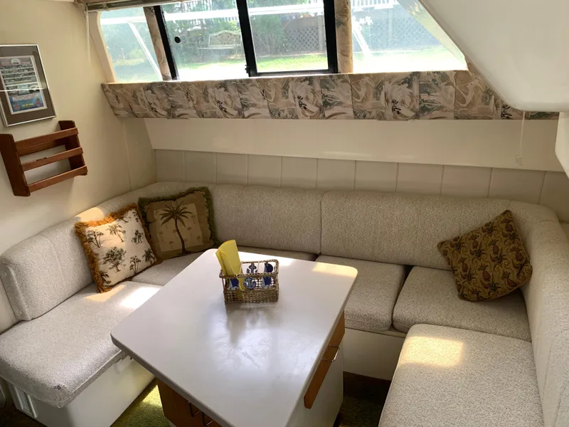 Slide: The Image of Cozy interior of 1994 Mainship 31 Sedan Bridge with cushioned seating and decorative pillows. - 9